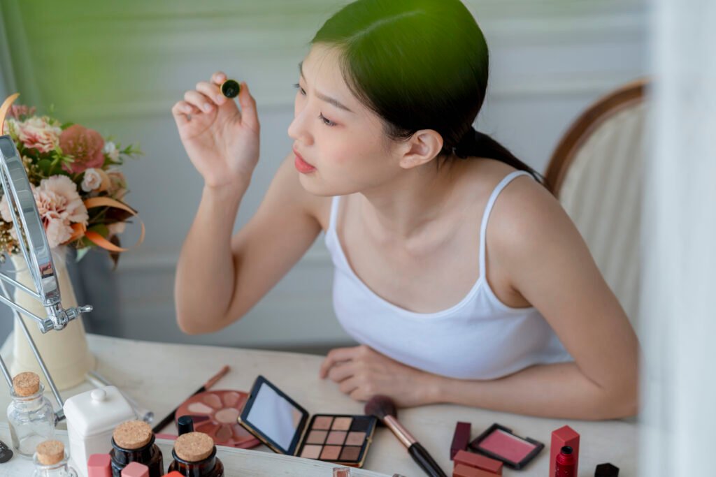 beautiful asian woman white tshirt smile with happiness hand hold blush on and makeup cosmetic items in bedroom with healthy face skincare concept